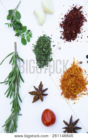 Dry Spices And Herbs In Glass Jar With A Cork, A Bowl Of Cherry Tomatoes And Chili Peppers, White Ba
