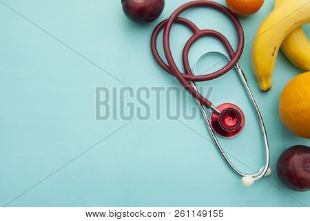 Medicine And Healthcare, Nutrition Or Medical Insurance Over Blue Background. Fruits And Red Sthetos