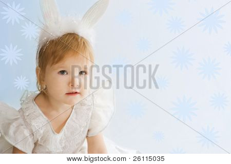 pretty baby in abito da festa coniglio orecchio e cnowflake su sfondo blu