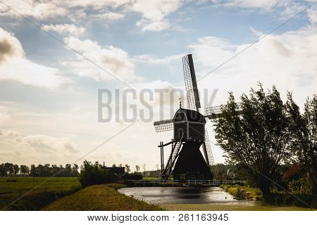 Silhouette Of A Wooden Hollow Post Mill In A Dutch Polder. The Wingerdse Molen Near The Village Of B