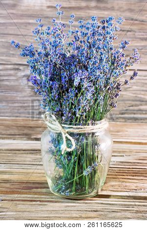 Vertical Photo Of A Bouquet Of Lavender In A Glass Vase With A Neck Bandaged With A Rough Rope On A 