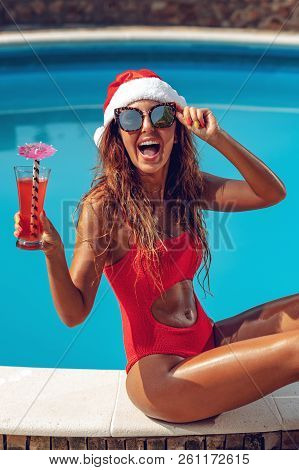 Young Beautiful Woman Near The Swimming Pool In Santa Claus Hat Celebrating New Year And Christmas I