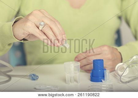 Home Treatment. Female Hand Puts Drug In A Nebuliser Container. Selective Focus