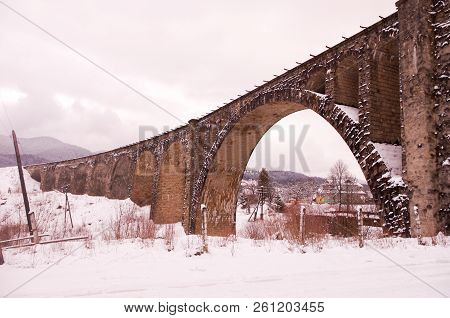 Large arch of a brick bridge. Old prewar bridge. Winter.