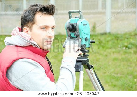 Civil Engineer Land Survey With Tacheometer Or Theodolite Equipment. Worker Checking Construction Si