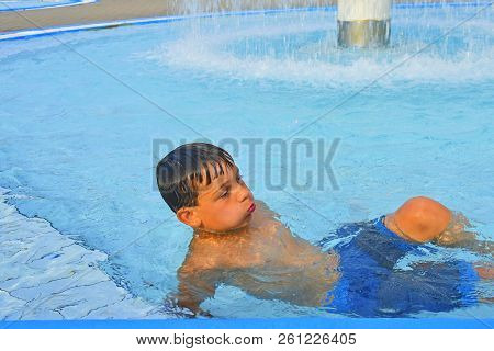 Summertime And Swimming Activities For Happy Children In The Pool. Cute Boy In Water Park. Summer An
