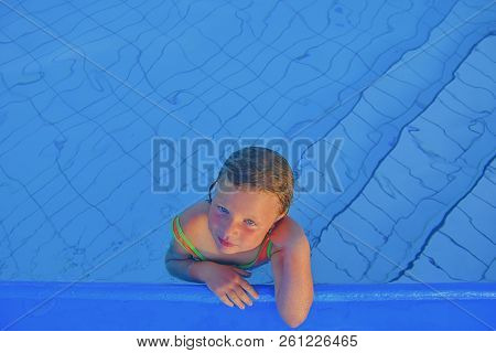 Cute Little Girl In The Public Swimming Pool. Portrait Of Little Cute Girl In The Swimming Pool. Sun