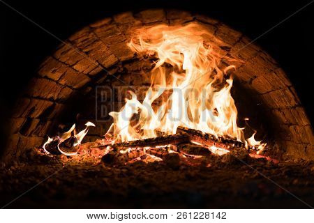 Close Up. Fire In The Oven. Pizza In The Coals. Dark Background. Concepts Of Cooking On A Fire In Th