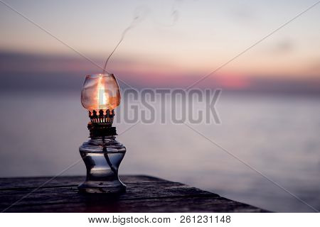 Close Up View Of Kerosene Lamp On Sunset Beach Back