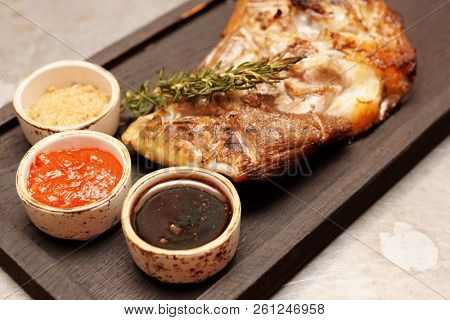 Braised and grilled leg of lamb with sauces on restaurant table