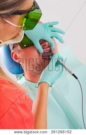 Dentist Using A Professional Dental Laser For Oral Treatment