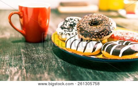 Assorted Donuts And Red Coffee Cup On Old  Wooden Table - Doughnuts On Yellow Plate With Tea Backgro