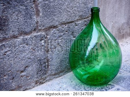 Vintage Large Green Glass Wine Bottle On The Sidewalk