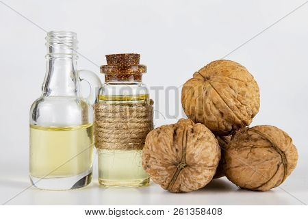 Oil In A Bottle And Walnuts On A White Kitchen Table. Spices And Ingredients Useful In Kuchi.
