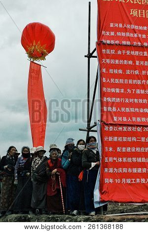 Labrang Monastery, Xiahe, Gansu Province / China - Jun 6 2011: Pilgrims Are Waiting Next To A Large 