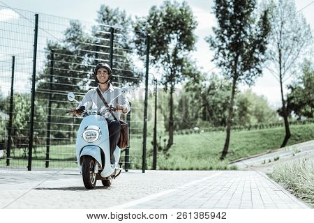 Merry Male Student Riding To University On Motorbike
