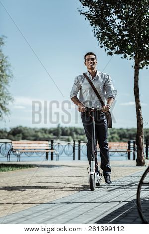 Jovial Merry Guy Riding Down Street On Scooter