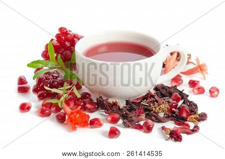 Parts Of A Pomegranate With Pomegranate Seeds And Leaves, Flowers, Dry Tea Of Carcade And Full Cup O