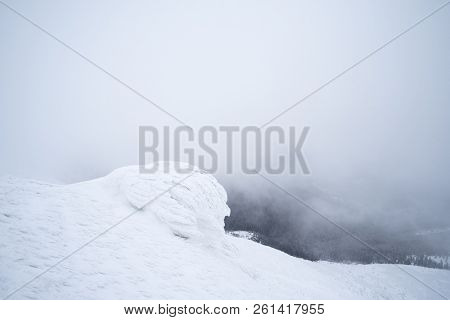 Snowy mountains in winter. Landscape with snow and fog.Rocks are covered with firn