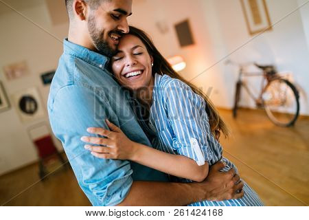 Beautiful Couple Hugging And Smiling At Home