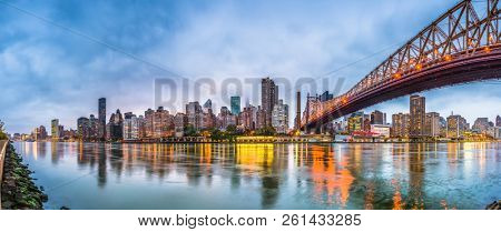  New York, USA skyline of Manhattan from across the East River with Queensboro Bridge at dusk.