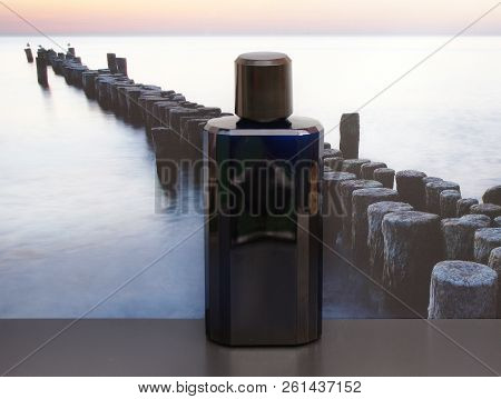 Eau De Toilette, Large Perfume Bottle In Front Of The Picture Of A Groyne In The Sea