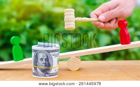 Wooden Figures Of People On Scales And Dollars Between Them. A Dispute Between Two Businessmen. Tria