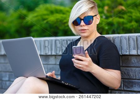 Portrait Young Girl Student In Sunglasses Plus Size Sits In The Yard, On Campus Talking On The Phone
