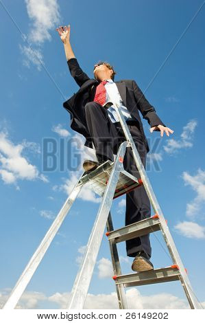 Een zakenman op een ladder bereiken van de hemel als de limiet dan de hemel is.