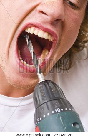 Uomo con la bocca spalancata, foratura in proprio i denti con un trapano.
