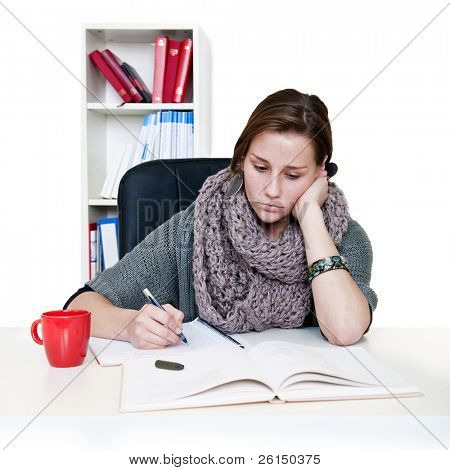 Donna giovane stanca senza meta a guardare i suoi libri, cercando di studiare