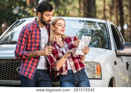 Shocked Young Man With Coffee Cup Standing Near Girlfriend While She Using Digital Tablet Near Pick 
