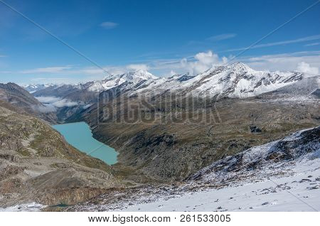 View To Stausee Lake Near Saas Fee In The Southern Swiss Alps From Monte Moro Pass, Italy