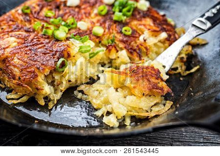 Traditional Swiss hash browns as side dish with leek as closeup in a frying pan 