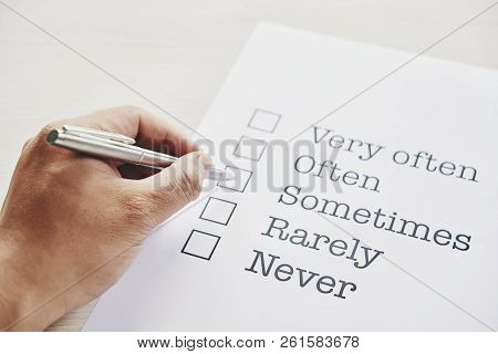 Hand Of Person Drawing Check Mark Against Sometimes Word In Application Form