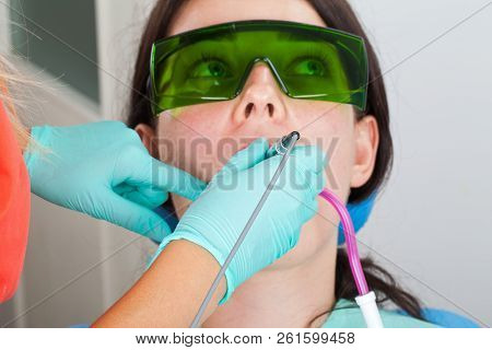 Dentist Using A Professional Dental Laser For Oral Treatment