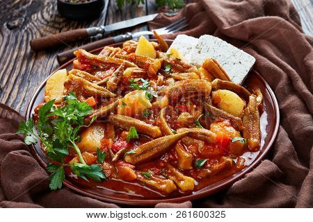 Stewed Okra With Tomato And Potato, Served With Feta Cheese Slices On A Earthenware Plate On A Rusti