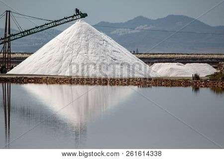 Saltmine Pile With Machines And Water Reflection