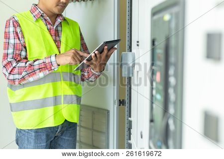 Asian Maintenance Engineers Inspect Relay Protection System With Laptop Computer. Bay Control Unit. 