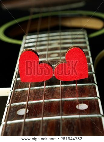 Red Hearts On The Strings Of A Guitar. Hearts Are A Symbol Of Love. Strings Of The Heart.