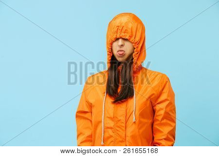 The Young Girl Posing At Studio In Autumn Jacket Isolated On Blue. Human Negative Emotions. Concept 