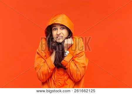 The Young Girl Posing At Studio In Autumn Jacket Isolated On Red. Human Negative Emotions. Concept O