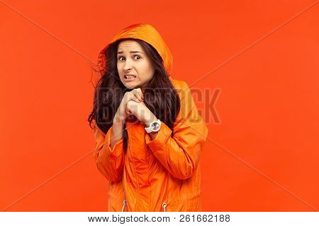 The Young Girl Posing At Studio In Autumn Jacket Isolated On Red. Human Negative Emotions. Concept O