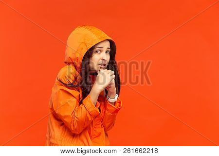 The Young Girl Posing At Studio In Autumn Jacket Isolated On Red. Human Negative Emotions. Concept O