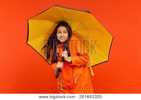 The Young Girl Posing At Studio In Autumn Jacket Isolated On Red. Human Negative Emotions. Concept O