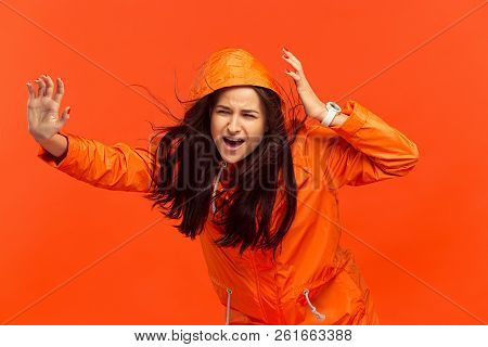 The Young Girl Posing At Studio In Autumn Jacket Isolated On Red. Human Negative Emotions. Concept O