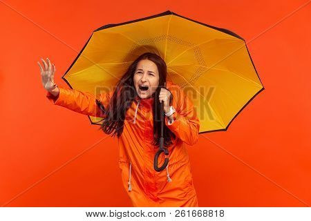 The Young Girl Posing At Studio In Autumn Jacket Isolated On Red. Human Negative Emotions. Concept O