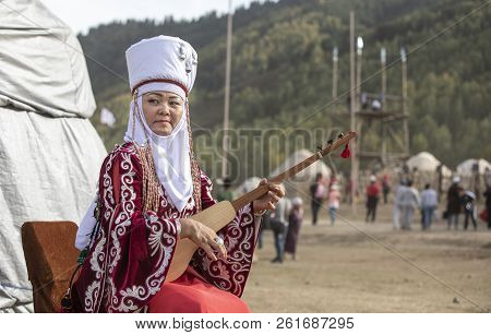 Lake Issyk-kul, Kyrgyzstan, 6th September 2018: Local Lady In Full Kyrgyz Outfit, Playing Komuz, Dur