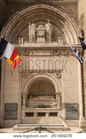 Dunkerque, France - September 16, 2018: Closeup Of World Wars Memorial With Flags At Base Of Belfry 