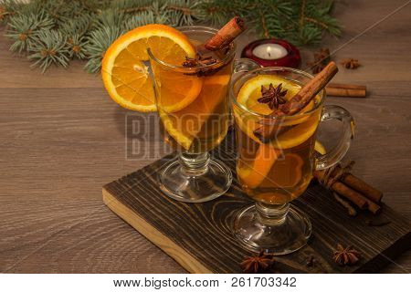 Two Glasses With Delicious Fragrant Tea Of Mulled Wine With Orange And Spices On A Wooden Board With
